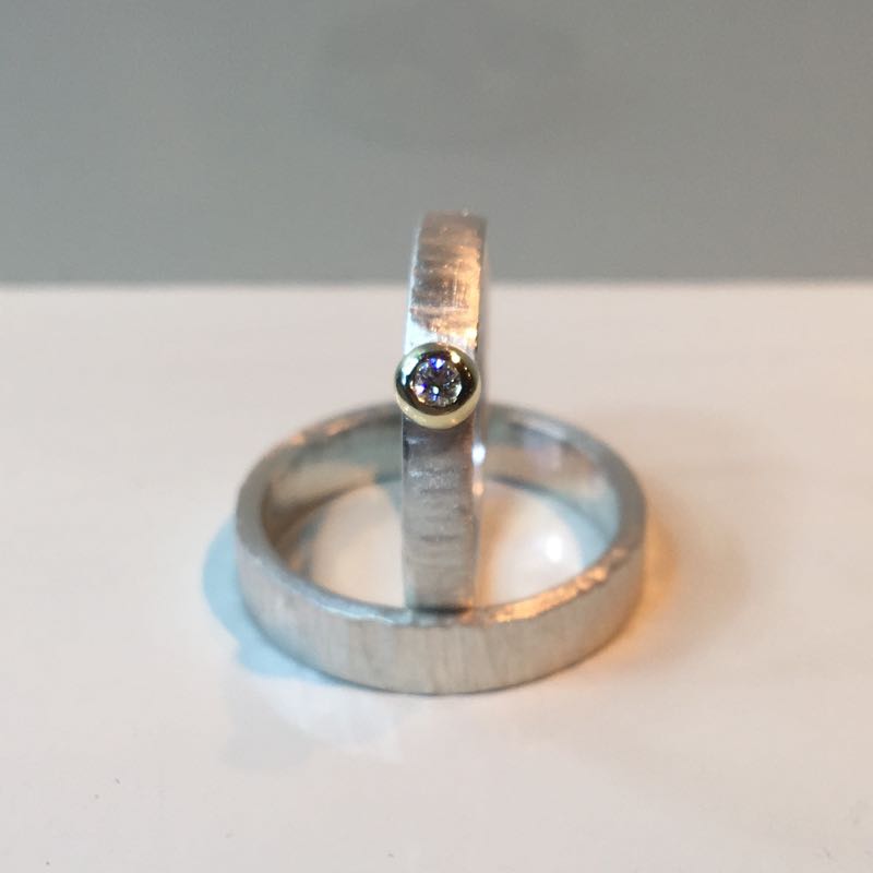Witgouden ring gehamerd en gematteerd met geelgoud zetkastje en diamant.