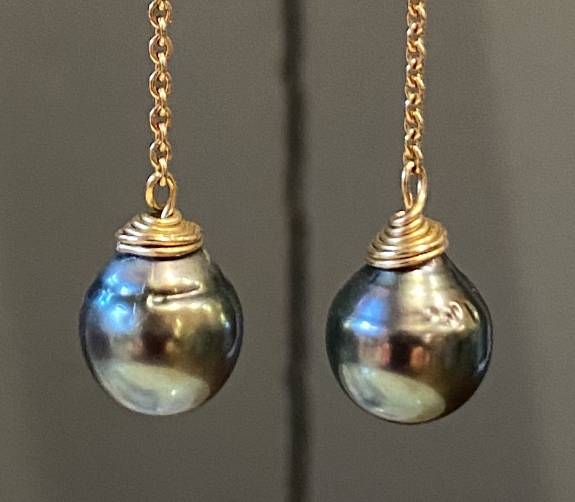 Geel gouden oorhangers met Tahiti parels aan kettinkje en diamanten in het oor.