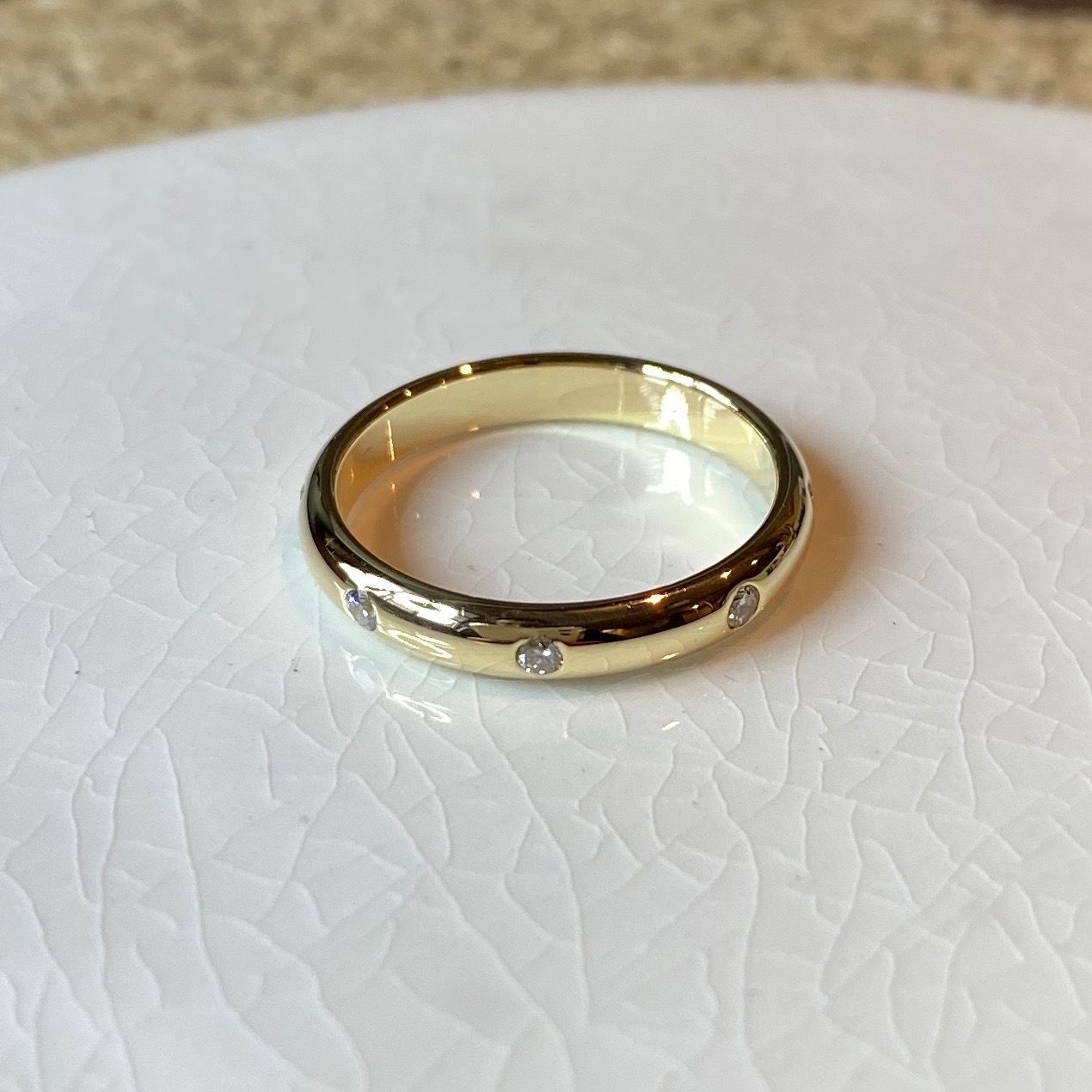 Geel gouden trouwring glans met rondom met een speelse afstand diamanten briljant geslepen.