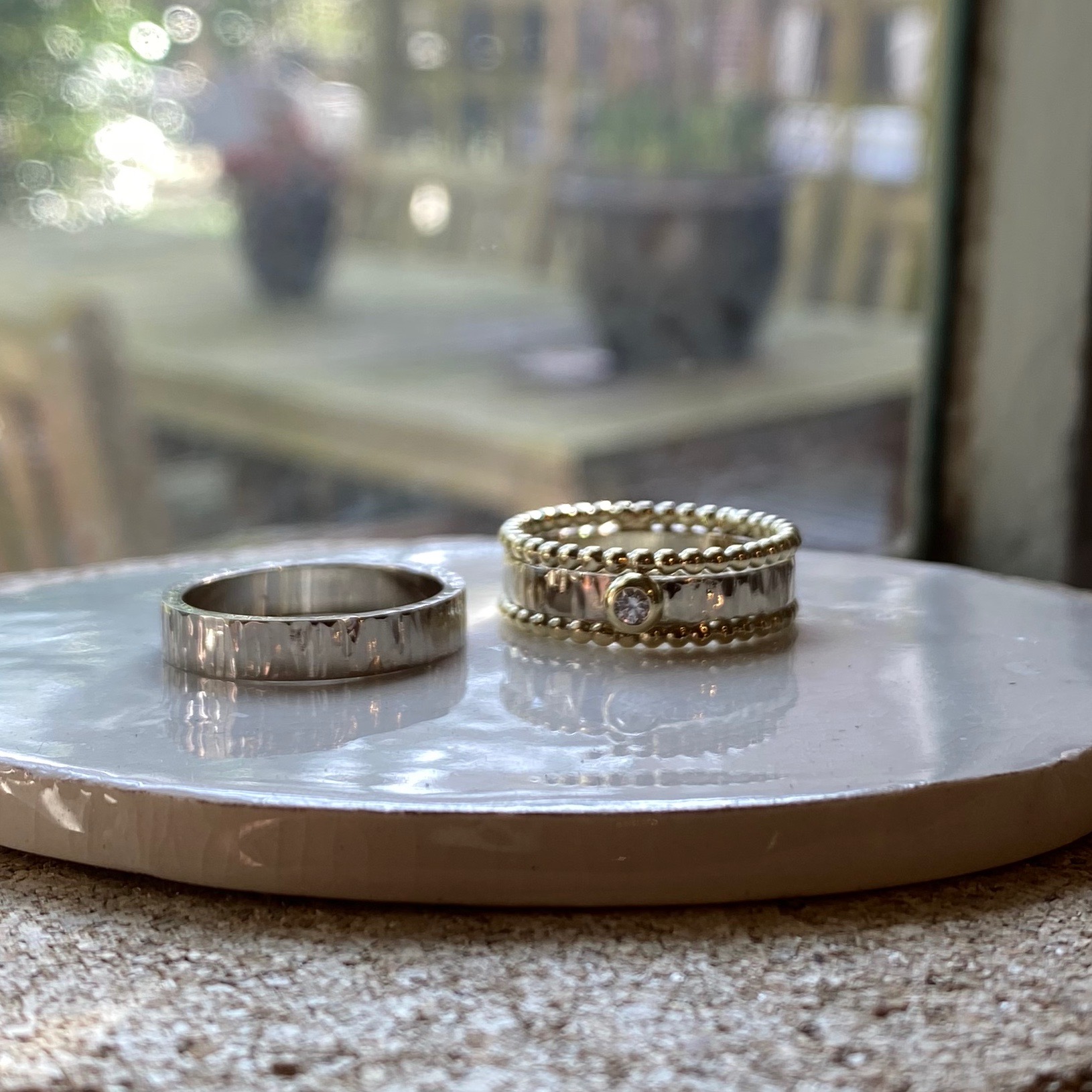 met voor de dame geel gouden bolletjes ring eraan en diamant in bol zetting.